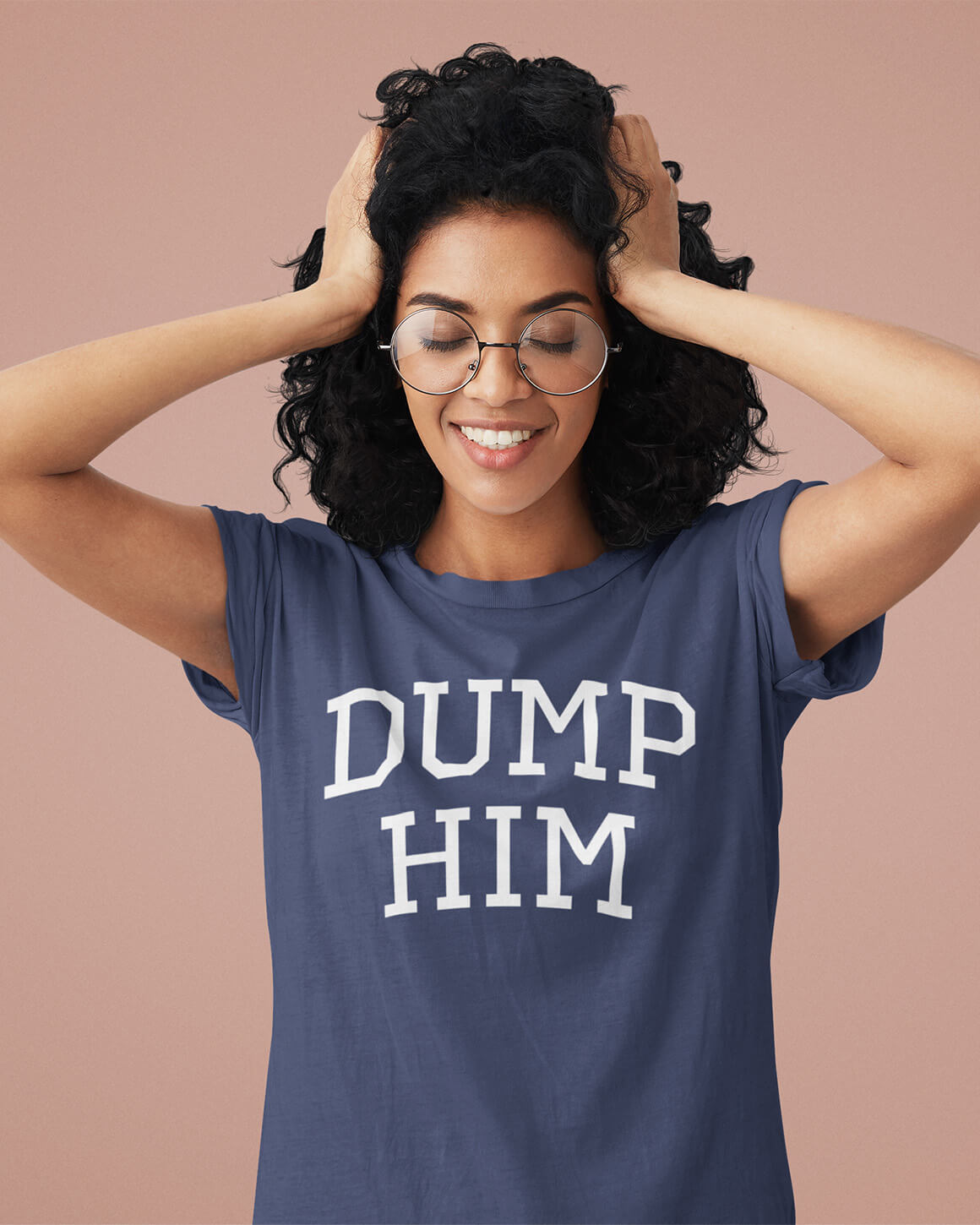 Woman wearing a navy t-shirt that boldly reads dump him