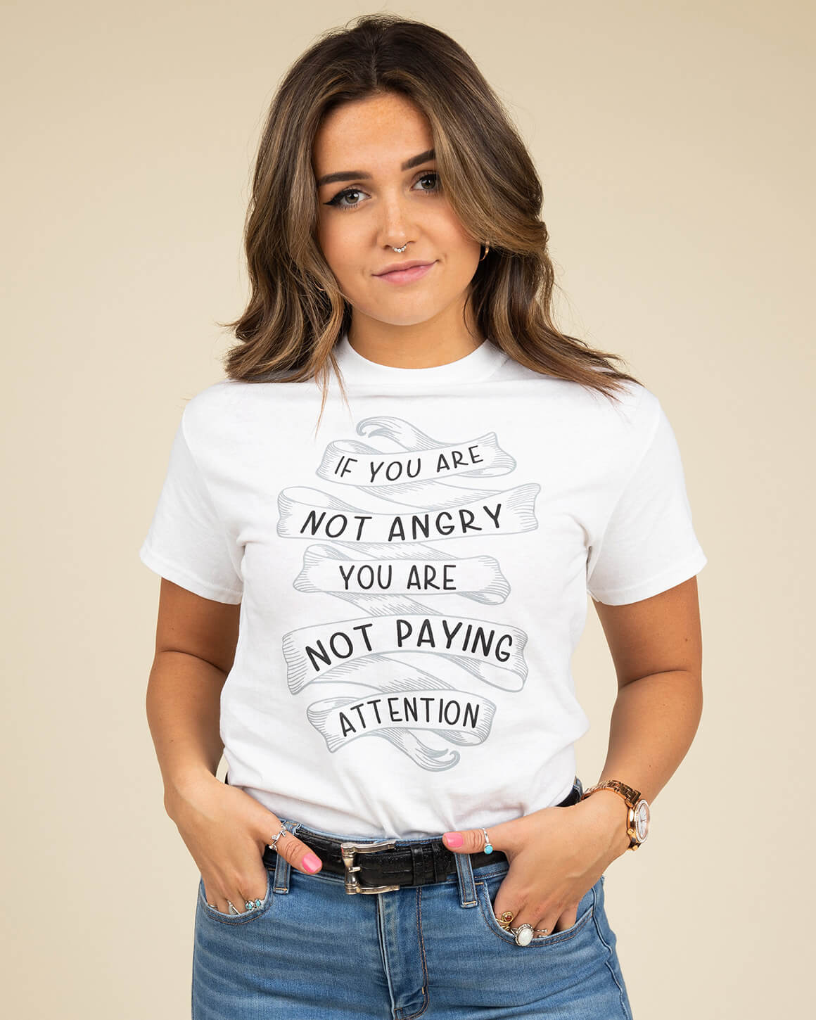 Young woman proudly wearing “if you’re not angry you’re not paying attention” feminist t shirt 