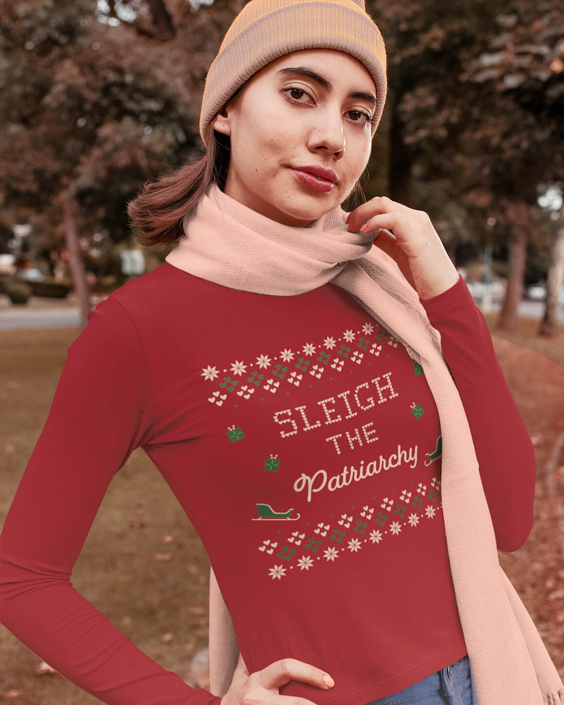 Woman outside in a scarf, beanie, and red long sleeve feminist t-shirt