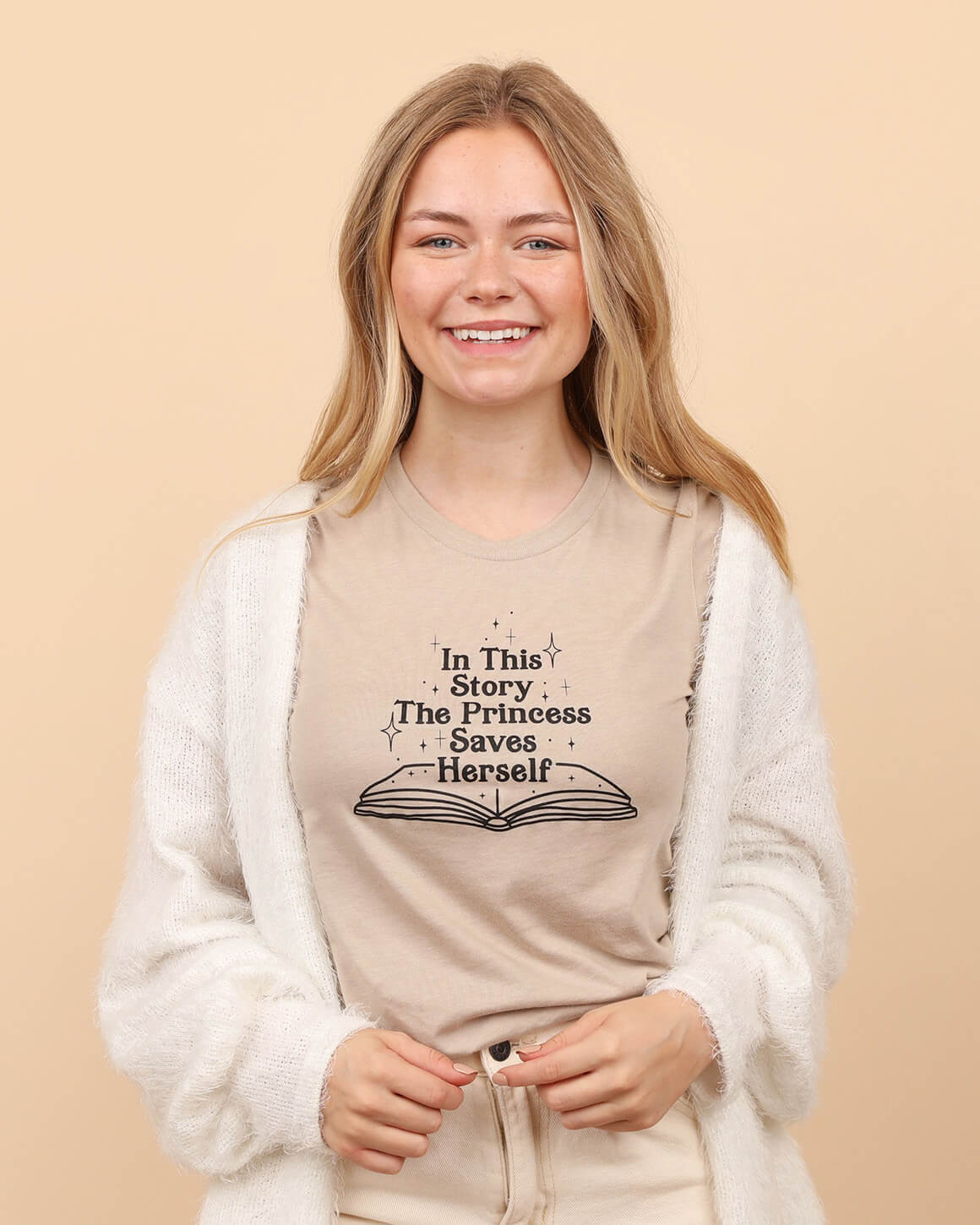 Smiling model in a tan t-shirt with a feminist graphic design